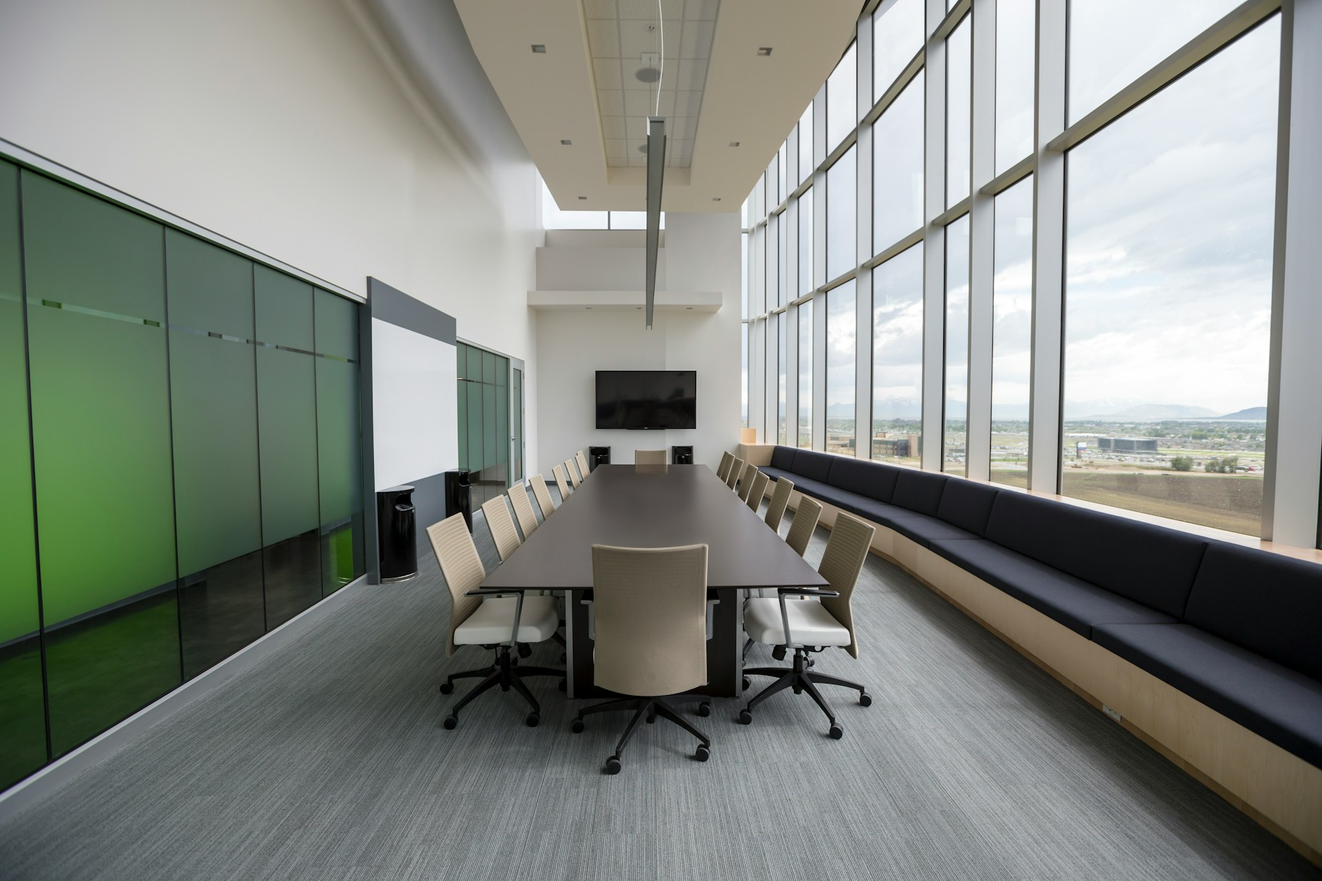 An empty meeting room, with a long table and unoccupied chairs around it